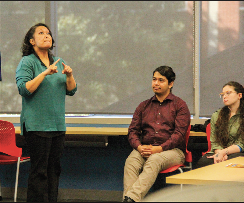 TR student Joyce Abell practices her sign language by interpreting William
Meadow’s presentation about historical communication methods in the military.